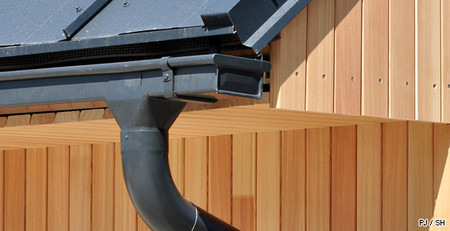 Gouttière en zinc noir sur maison en bois